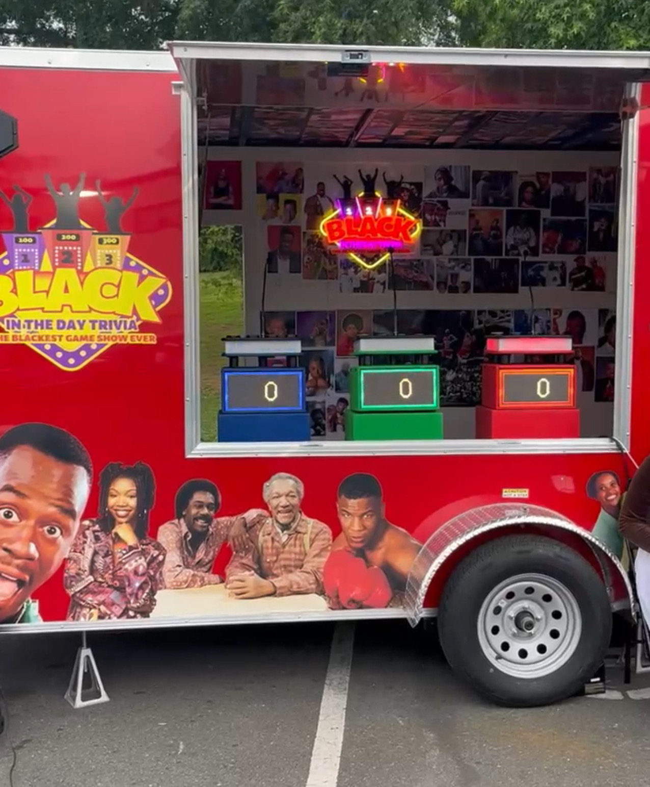 The branded Black In The Day Trivia trailer with its open stage and lit-up contestant podiums